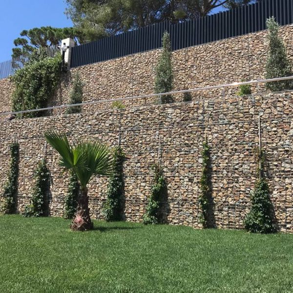 Welded gabions are installed as the exterior wall of the house